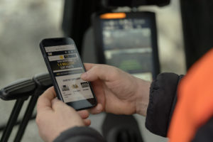 A man using Parts.Cat.Com on a smart phone to order equipment parts online